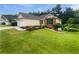 Landscaped lawn surrounds this light-colored home featuring brick accents and a driveway with space for two vehicles at 6560 Alford Way, Lithonia, GA 30058