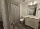 Bright bathroom featuring a shower-tub combo, grey tile floors and a white vanity at 401 Burton Dr, Alpharetta, GA 30009