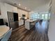 Bright kitchen with stainless steel appliances, a large island with seating, and hardwood flooring at 401 Burton Dr, Alpharetta, GA 30009