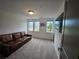 Spacious living room with a comfortable brown leather sofa and three large windows at 401 Burton Dr, Alpharetta, GA 30009