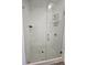 Tiled walk-in shower featuring a frameless glass door and a shower rack at 401 Burton Dr, Alpharetta, GA 30009
