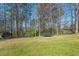 Well-maintained, spacious backyard featuring mature trees, lush greenery, and a trampoline at 5826 Little Mountain Dr, Ellenwood, GA 30294
