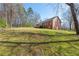 Expansive backyard featuring lush lawn and mature trees, with a deck overlooking the serene landscape at 5826 Little Mountain Dr, Ellenwood, GA 30294