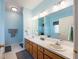 Light-filled bathroom featuring a large mirror over dual sinks and vanity at 5826 Little Mountain Dr, Ellenwood, GA 30294