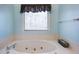 Bright bathroom features a large soaking tub under a window for natural light at 5826 Little Mountain Dr, Ellenwood, GA 30294