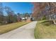 Driveway leading to a brick home with a covered porch, surrounded by mature trees and landscaping at 5826 Little Mountain Dr, Ellenwood, GA 30294