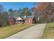 Brick home with a long driveway, featuring a charming covered porch and attached garage at 5826 Little Mountain Dr, Ellenwood, GA 30294
