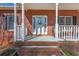 Inviting front porch with brick steps and classic columns, perfect for relaxing outdoors at 5826 Little Mountain Dr, Ellenwood, GA 30294