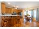 Open kitchen with wood cabinets, stainless steel appliances, breakfast bar, and adjacent dining area with natural light at 5826 Little Mountain Dr, Ellenwood, GA 30294