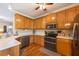 Well-lit kitchen with wood cabinets, stainless steel appliances, hardwood floors, and white countertops at 5826 Little Mountain Dr, Ellenwood, GA 30294