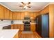 Well-lit kitchen with wood cabinets, stainless steel appliances, hardwood floors, and white countertops at 5826 Little Mountain Dr, Ellenwood, GA 30294