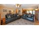 Inviting living room featuring comfortable leather sofas, a patterned rug, and seamless flow to the kitchen and dining area at 5826 Little Mountain Dr, Ellenwood, GA 30294