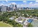 Aerial view showcasing modern city buildings, lush green parks, tennis courts, and swimming pools at 893 Piedmont Ne Ave # 3, Atlanta, GA 30309