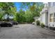 Wide view of the building's parking lot with a black car and greenery visible at 893 Piedmont Ne Ave # 3, Atlanta, GA 30309