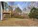 Large grassy backyard with a wooden deck under a wooded canopy of trees at 247 Mandy Ct, Mcdonough, GA 30252