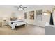 Bright bedroom featuring a ceiling fan, and neutral decor with carpet floors and a bench at the foot of the bed at 247 Mandy Ct, Mcdonough, GA 30252