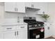 A close-up of stainless steel oven with white cabinets, subway tile backsplash, and wood floors at 247 Mandy Ct, Mcdonough, GA 30252