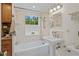 Bright bathroom featuring a tub with shower, vanity, and natural light from the window at 3449 Parkview Dr, Atlanta, GA 30337