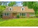 Charming brick home with a lush green lawn, dormer windows, and verdant landscaping at 3449 Parkview Dr, Atlanta, GA 30337
