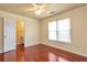Bright bedroom with hardwood floors, ceiling fan, and natural light from the windows at 4095 Boles Creek Dr, Duluth, GA 30096