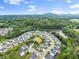 Scenic aerial view of a residential community with tree-lined streets, a pond, and mountain views in the distance at 4105 Woodwind Dr, Cumming, GA 30028