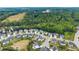 Overhead shot of a suburban neighborhood bordering lush greenery and a tranquil lake, highlighting community layout at 4105 Woodwind Dr, Cumming, GA 30028