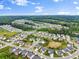Expansive aerial view showcasing the layout of a sprawling suburban neighborhood surrounded by green forests and fields at 4105 Woodwind Dr, Cumming, GA 30028