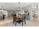Dining area with a round wooden table, black chairs, modern light fixture, and an open-concept kitchen at 4105 Woodwind Dr, Cumming, GA 30028