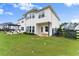 Back exterior showcasing the home's architecture, outdoor patio area, and spacious yard at 4105 Woodwind Dr, Cumming, GA 30028