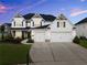 Stately two-story home featuring a manicured lawn and three-car garage at 4105 Woodwind Dr, Cumming, GA 30028