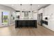 Bright kitchen with white cabinets, hardwood floors, center island with stools, and stainless appliances at 4105 Woodwind Dr, Cumming, GA 30028