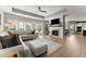 Spacious living room with hardwood flooring, a modern fireplace, and multiple windows for natural light at 4105 Woodwind Dr, Cumming, GA 30028