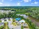 Overhead view of a community pool, clubhouse, and tennis courts nestled among homes and a serene lake setting at 4105 Woodwind Dr, Cumming, GA 30028