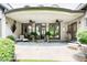 Covered back patio with ceiling fans, stone floor, lounge chairs, and glass doors overlooking wooded backyard at 115 Cross Roads Ct, Atlanta, GA 30327