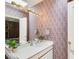 Bright bathroom with patterned wallpaper, vanity sink with chrome faucet, and a large mirror at 115 Cross Roads Ct, Atlanta, GA 30327