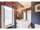 Stylish bathroom featuring blue striped wallpaper, a modern vanity, a window, and elegant fixtures at 115 Cross Roads Ct, Atlanta, GA 30327
