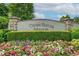 Entrance sign to Crossroads Manor, adorned with colorful flower beds and lush greenery at 115 Cross Roads Ct, Atlanta, GA 30327