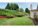 Large grassy yard with stairway against hillside bordering a house with a screened patio at 199 Eastham Ct, Suwanee, GA 30024
