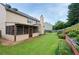 Spacious backyard with lush lawn, mature trees, patio, and landscaped gardens, perfect for entertaining at 199 Eastham Ct, Suwanee, GA 30024