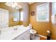 Bathroom featuring a single sink vanity, toilet, and a window for natural light at 199 Eastham Ct, Suwanee, GA 30024