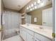 Bright bathroom featuring a double sink vanity and shower-tub combo with neutral color palette at 199 Eastham Ct, Suwanee, GA 30024
