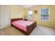 Bedroom with yellow walls, wood furniture, carpet flooring and natural light from two windows at 199 Eastham Ct, Suwanee, GA 30024