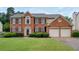 Traditional brick home with two-car garage, manicured lawn and green shrubbery at 199 Eastham Ct, Suwanee, GA 30024