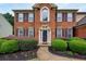 Close up of a charming brick home with a manicured lawn and pathway to front door at 199 Eastham Ct, Suwanee, GA 30024