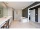 Bathroom featuring double sinks, a soaking tub, and a doorway leading to the bedroom at 199 Eastham Ct, Suwanee, GA 30024