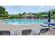Community pool with ample lounge seating and adjacent clubhouse surrounded by mature trees at 199 Eastham Ct, Suwanee, GA 30024