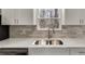 Close-up of a kitchen sink and quartz countertop, with gray tile backsplash and stainless steel faucet at 2216 Marbut Farms Trce, Lithonia, GA 30058