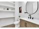 Chic half-bath with stylish black fixtures, marble countertop, wood-look vanity, and floating shelves at 2497 Wawona Dr, Brookhaven, GA 30319