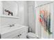 Cozy bathroom featuring a white vanity, toilet, and shower with decorative curtain at 50 Ormond Sw St, Atlanta, GA 30315