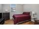 Bedroom with hardwood floors, a window, a dresser, a side table, and a red bedspread at 50 Ormond Sw St, Atlanta, GA 30315